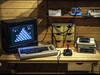 一台运行《Q*Bert》游戏的 Commodore 64 计算机，旁边配有 1541 软盘驱动器和磁带驱动器，用于向其 64KB 内存中加载软件。
