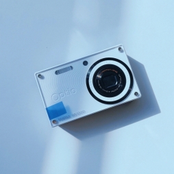 分享一款便携的数码相机--Pentax Optio RS1000，火柴盒造型加白色机身，背面磨砂黑色外壳，按钮布局十分简洁。